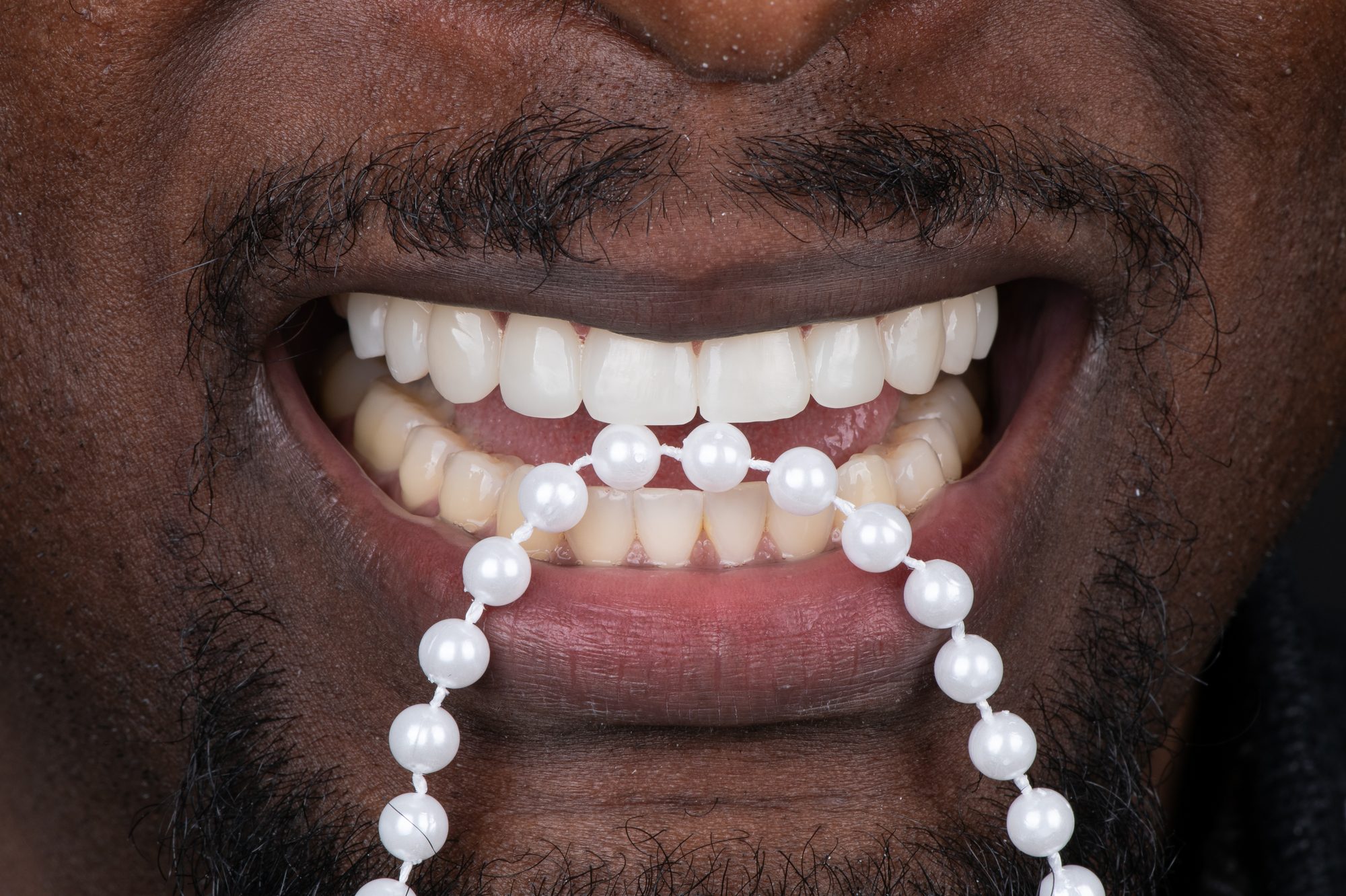 A Smile On Nashville patient with bright PERL veneers and a strand of pearls