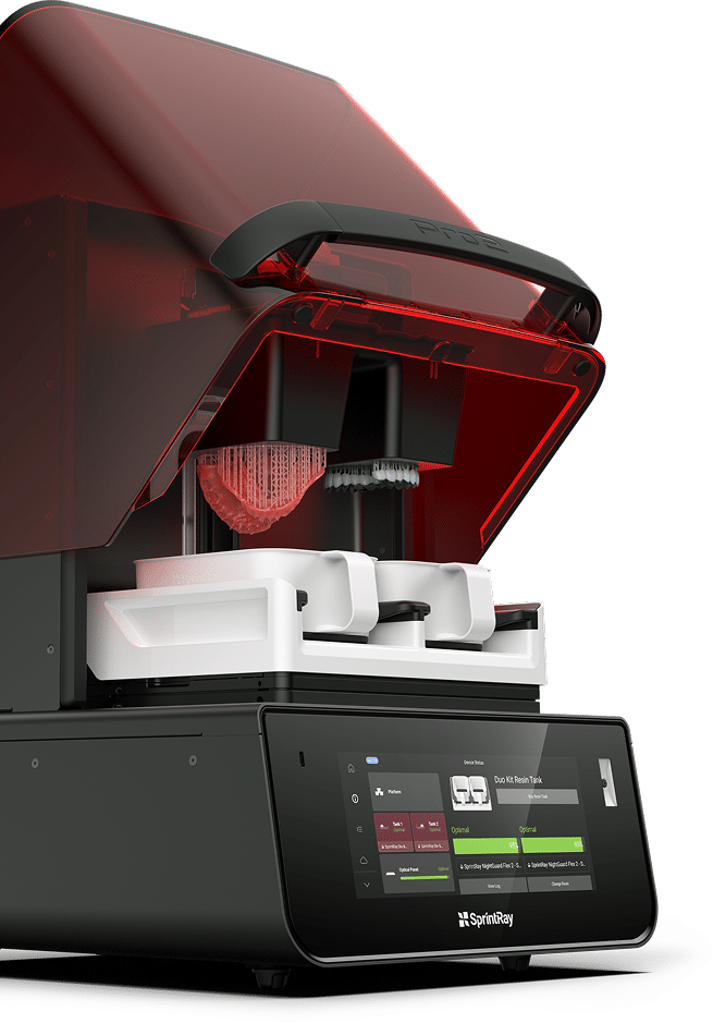 A SprintRay 3D printer with its lid open, printing a white dental arch